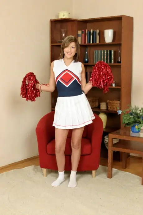 Amateur Linda Red takes off her clothes until only her socks remain, holding pom-poms