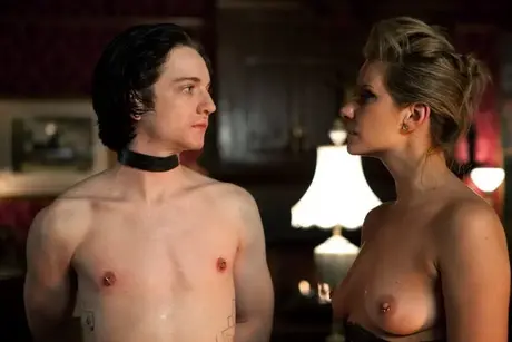 Femme dominante caressant un esclave masculin attaché puis l'embrassant