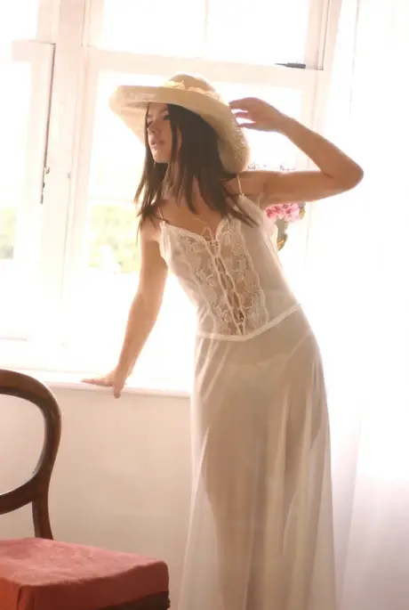 Solo model with long hair reveals firm breasts and a tight rear while nude