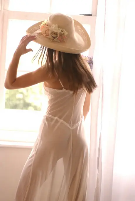 In the nude, a long-haired solo model showcases her firm breasts and tight rear