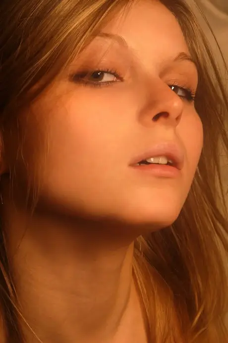 Svůdná blond modelka zcela nahá na židli ve tmě