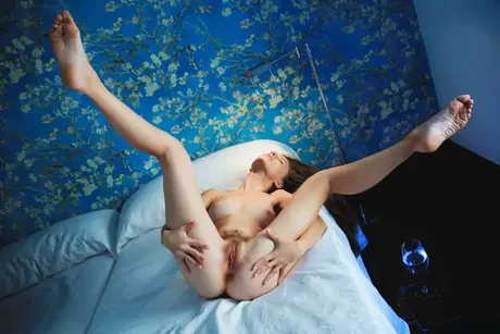 Sofi Shane se na posteli vedle sklenice vody svlékne úplně donaha