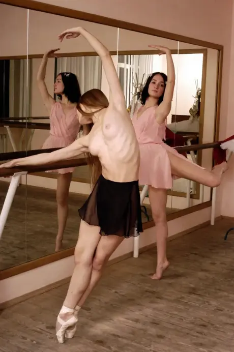 While at the barre, ballerinas stretch and bare small breasts
