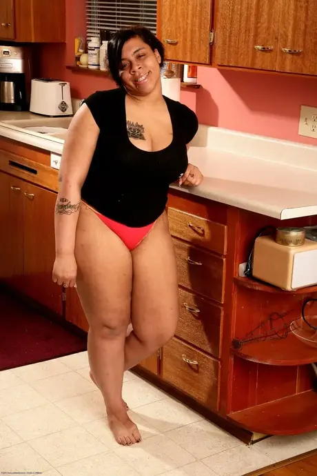 Nykole, la belle ébène poilue, exhibe ses gros seins et son super cul dans la cuisine