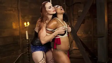 De lange lesbische dominatrix Bella Rossi die een strap-on gebruikt op de voluptueuze ebbenhouten Bella Rossi