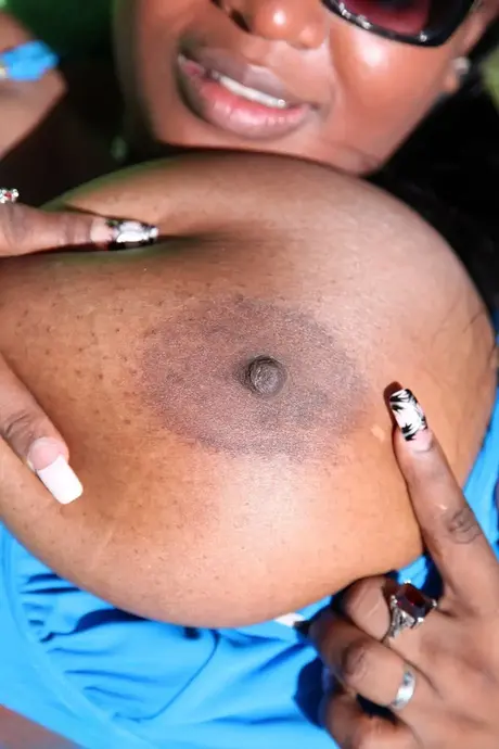 A amadora Jenny, de pele escura, mostra seus enormes peitos em um ensaio ao ar livre