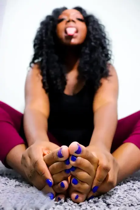 La beauté ébène Chy Latte aguiche avec ses pieds et ses ongles d'orteils sur le sol