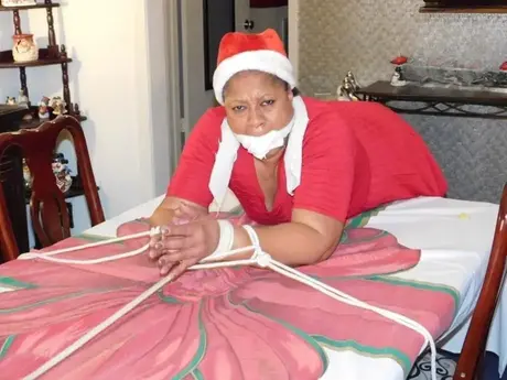 Ebony BBW sidottuna pöydälle jouluna, alusvaatteet paljastettuina