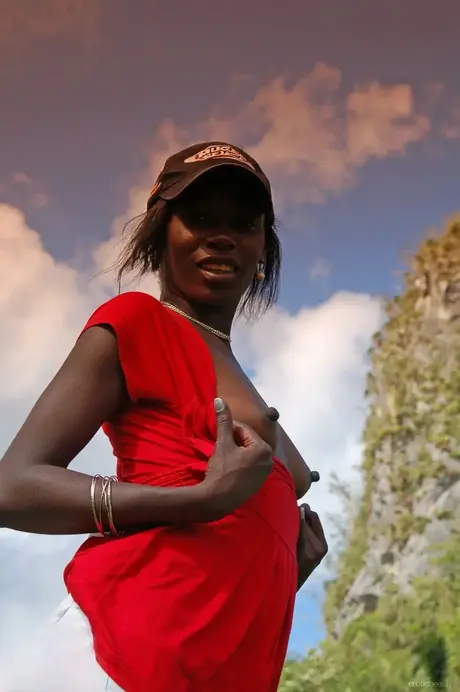 Ebony Maria L si sundá šortky a červené tričko a venku koketně ukazuje zadek