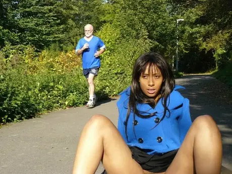 Donna dalla pelle scura si dà piacere sulla strada mentre passa un jogger