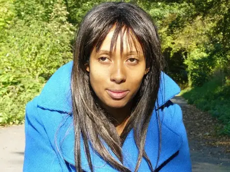 Donna dalla pelle scura si dà piacere sulla strada mentre passa un jogger