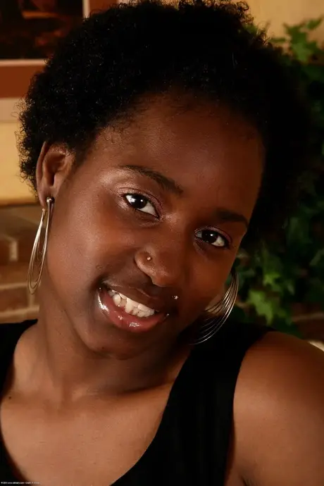 Donna nera nuda con afro che mostra le ascelle pelose e la figa