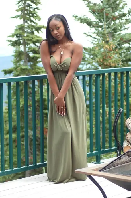 L'amatrice ébène Amber libère ses gros seins d'une longue robe sur un balcon