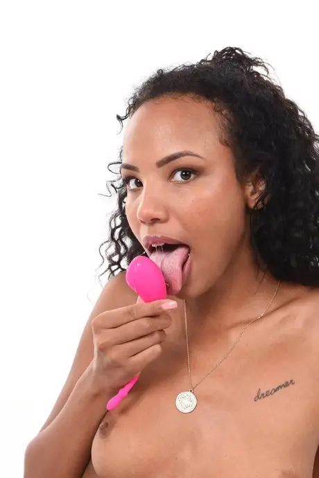 Romy Indy, una mujer negra, lame un juguete sexual y luego lo inserta en su vagina