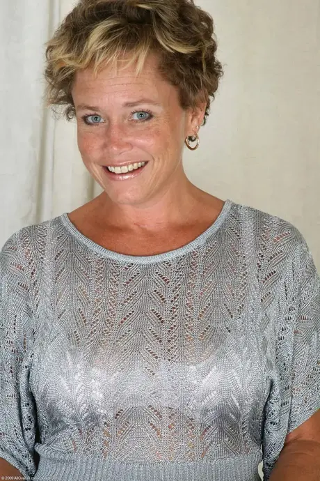 Ariel, den blåögda MILF:en med stora tuttar, klär av sig och poserar på ett bord