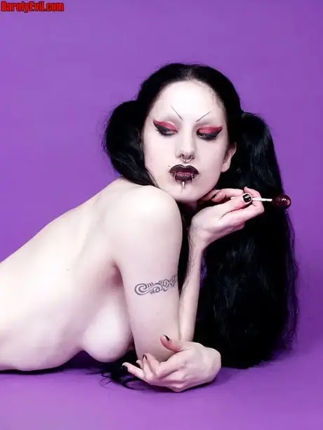 Fetus De Milo, deathrocková hudebnice, tahá za své copy, zatímco pózuje nahoře bez v punčochách