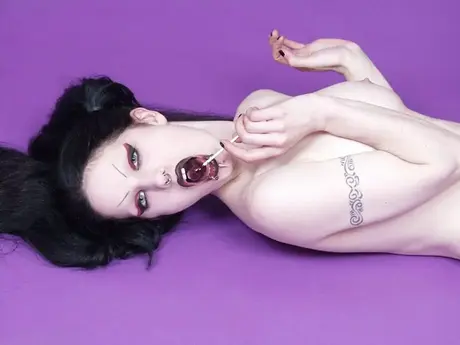 Fetus De Milo, deathrocková hudebnice, tahá za své copy, zatímco pózuje nahoře bez v punčochách