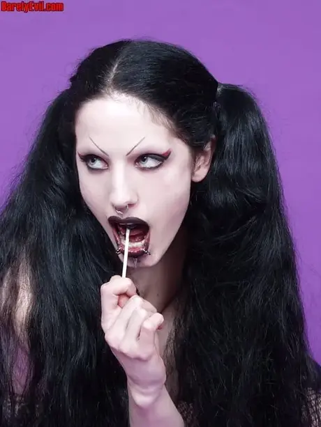 Fetus De Milo, deathrocková hudebnice, tahá za své copy, zatímco pózuje nahoře bez v punčochách
