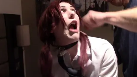Zrzavá studentka s růžovými kolíčky na prádlo na jazyku a obojkem