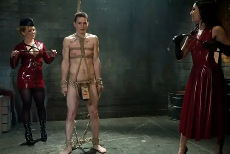Dia Zerva und January Seraph dominieren in Latex einen gefesselten Sklaven