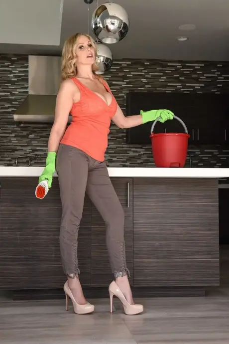 Die langbeinige Mom Julia Ann zieht ihre Latexhandschuhe aus, bevor sie sich in der Küche auszieht