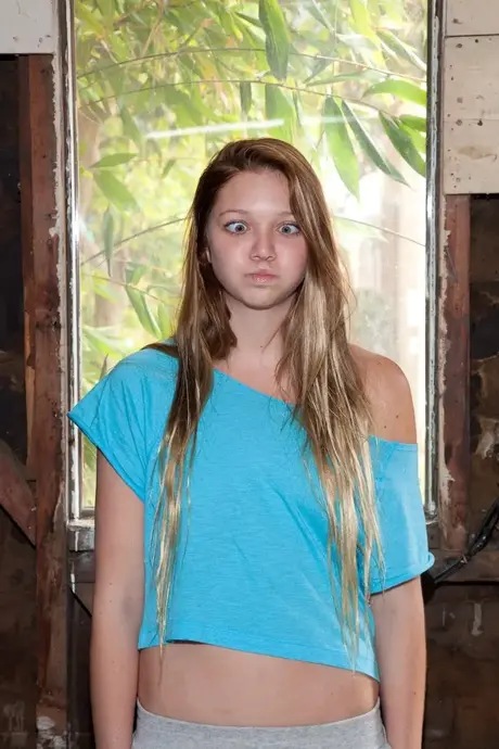 Tilly Hannon kler av seg på en seng, trusen rundt anklene