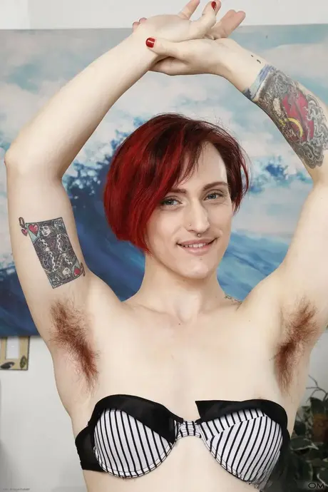 La rossa tatuata Lauren Laurent mostra il suo pelo dopo essersi tolta un reggiseno nero
