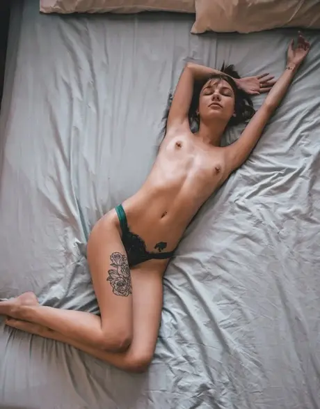Štíhlá kráska Eveelyn SG se po svléknutí uvolněně válí na posteli v tangách