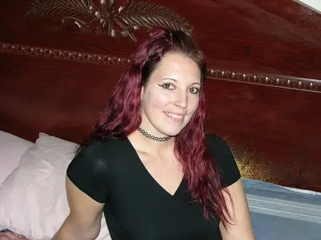La amateur pelirroja Ashley C se desnuda por completo en una cama