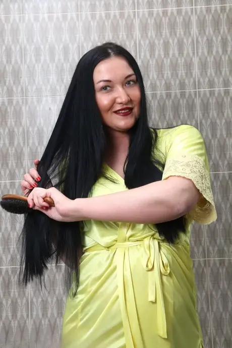 De bustige brunette boven de 30 Vanessa Vaughn borstelt haar lange haar voor haar bad