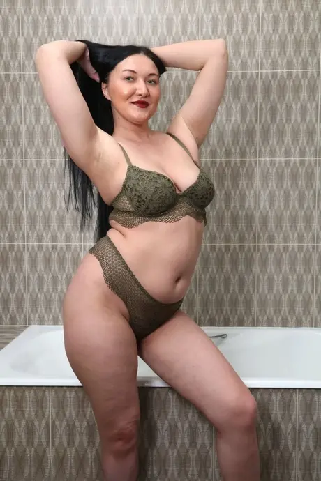 De bustige brunette boven de 30 Vanessa Vaughn borstelt haar lange haar voor haar bad