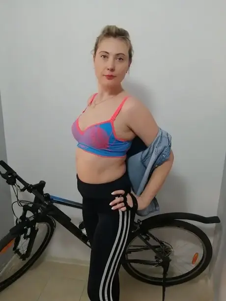 Ciclista aficionada con curvas se desnuda y posa desnuda sobre su bici