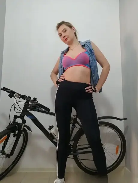 Ciclista aficionada con curvas se desnuda y posa desnuda sobre su bici
