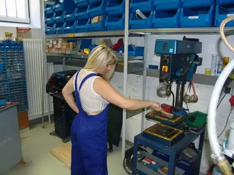 Une blonde mature retire sa salopette avant de se masturber dans l'atelier