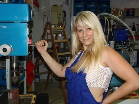 Una bionda matura si toglie la tuta prima di masturbarsi in officina