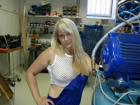 Una bionda matura si toglie la tuta prima di masturbarsi in officina