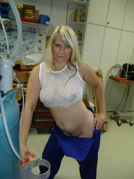 Una bionda matura si toglie la tuta prima di masturbarsi in officina