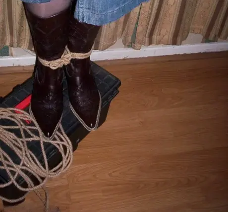 Amateurfrau zeigt ihre großen Brüste, während sie geknebelt und mit einem Strick um den Hals in einem Schlafzimmer ist
