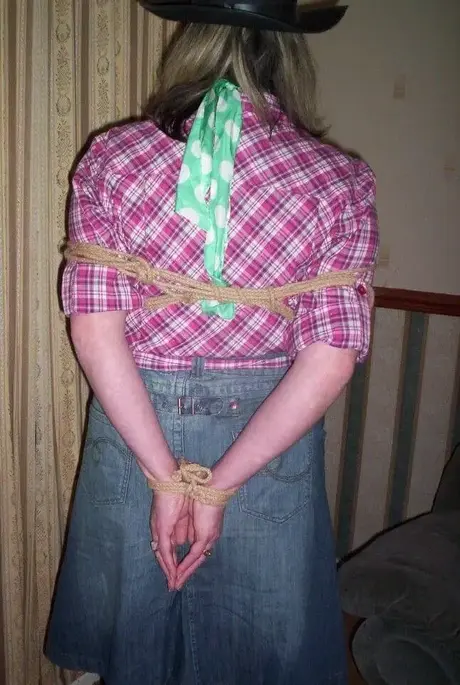 Amateurfrau zeigt ihre großen Brüste, während sie geknebelt und mit einem Strick um den Hals in einem Schlafzimmer ist