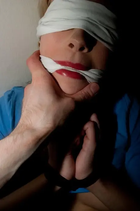 Donna amatoriale imbavagliata e con i polsi legati e i seni scoperti