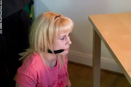 Mujer rubia atada con cuerda y amordazada, pechos expuestos