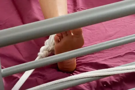 Mora legata con corda e nastro adesivo a un letto, nuda con capezzoli duri