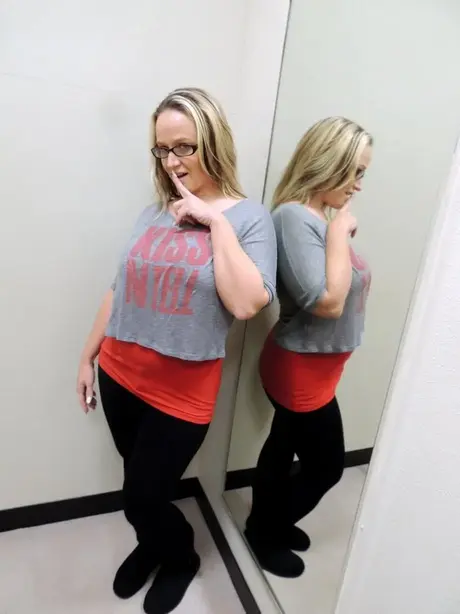 Dee Siren si abbassa i pantaloni davanti allo specchio di un camerino