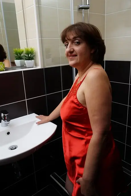 Reife Frau zeigt ihre großen natürlichen Brüste, bevor sie in der Dusche masturbiert