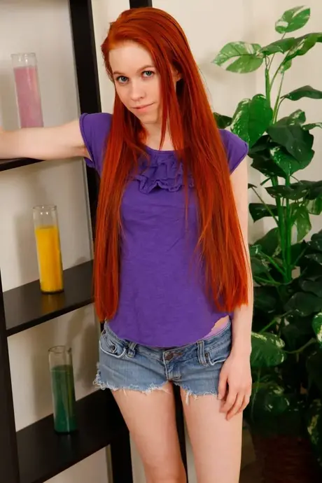 Drobna rudowłosa Dolly Little rozbiera się, rozchyla nogi i palcuje swoją gorącą cipkę