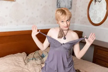 Amateur modelka s krátkými zrzavými vlasy roztahuje chlupatou píču na posteli
