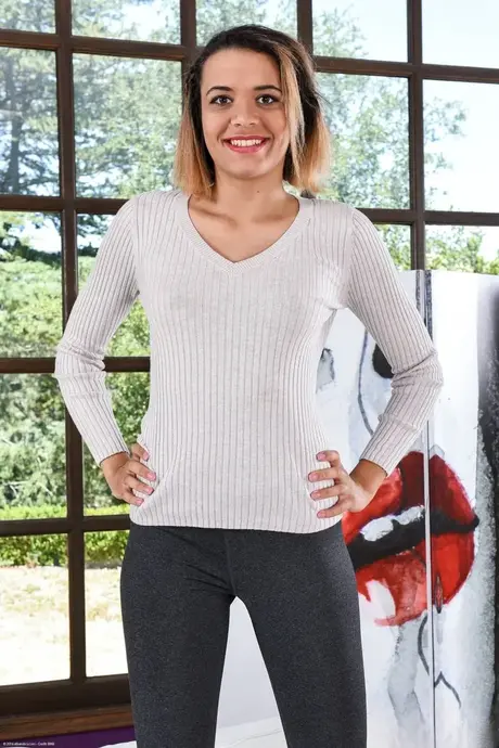 La joven adulta delgada Eve Ellwood se desnuda y se estira en una escena en solitario
