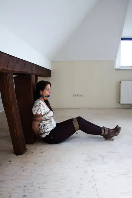 Amateur brunette Lena vastgebonden aan een houten tafel met een ball gag