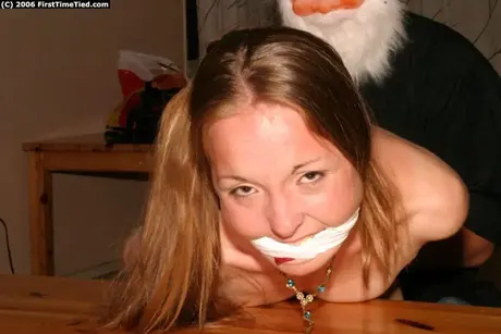 Amatérská žena spoutaná a s roubíkem od muže v masce Santa Clause