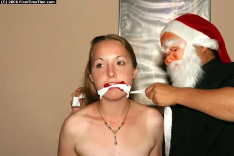 Amatérská žena spoutaná a s roubíkem od muže v masce Santa Clause